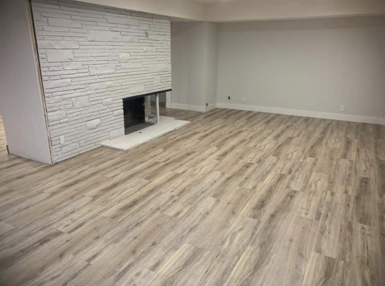 LVP flooring with white stone fireplace